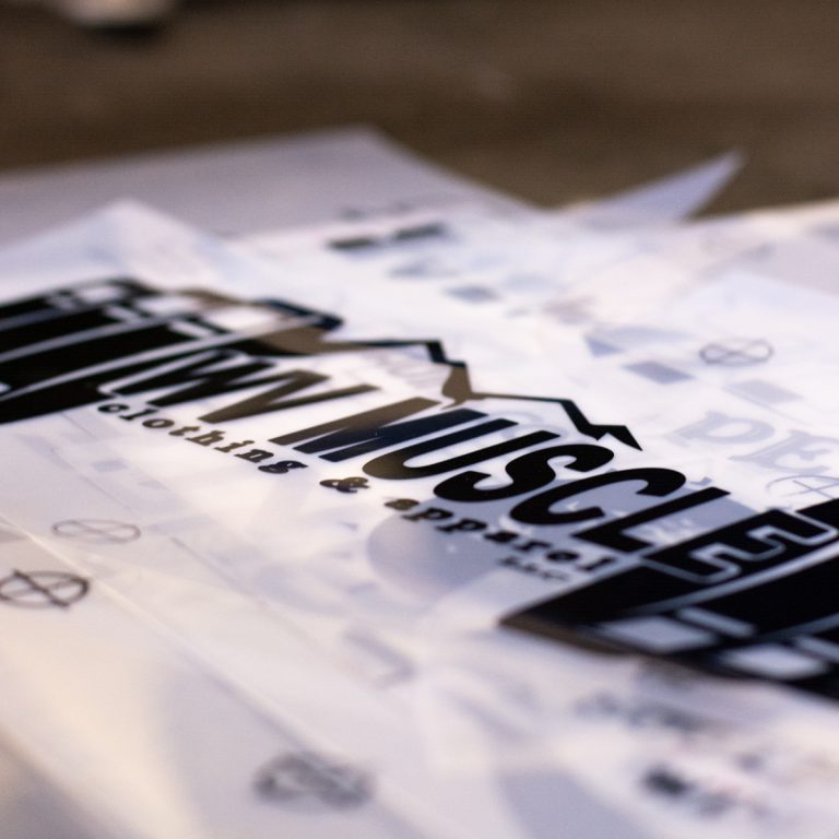 Hau Ink custom printing materials featuring "WVMuscle" logo and text, showcasing clothing and apparel design elements.