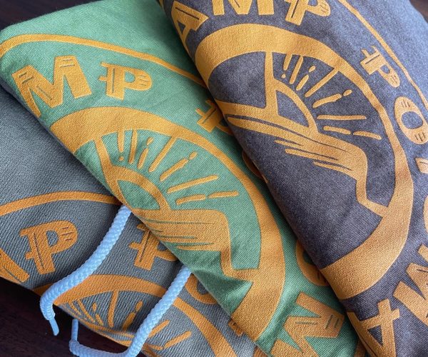 Colorful hooded sweatshirts featuring large graphic prints, showcasing designs in green, brown, and orange, representing custom apparel options available for small businesses at Hau Ink.